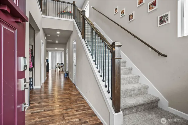 a view of staircase with lots of frames on wall and a table