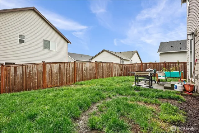 a view of backyard with wooden fence