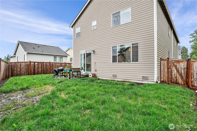 a backyard of a house with table and chairs