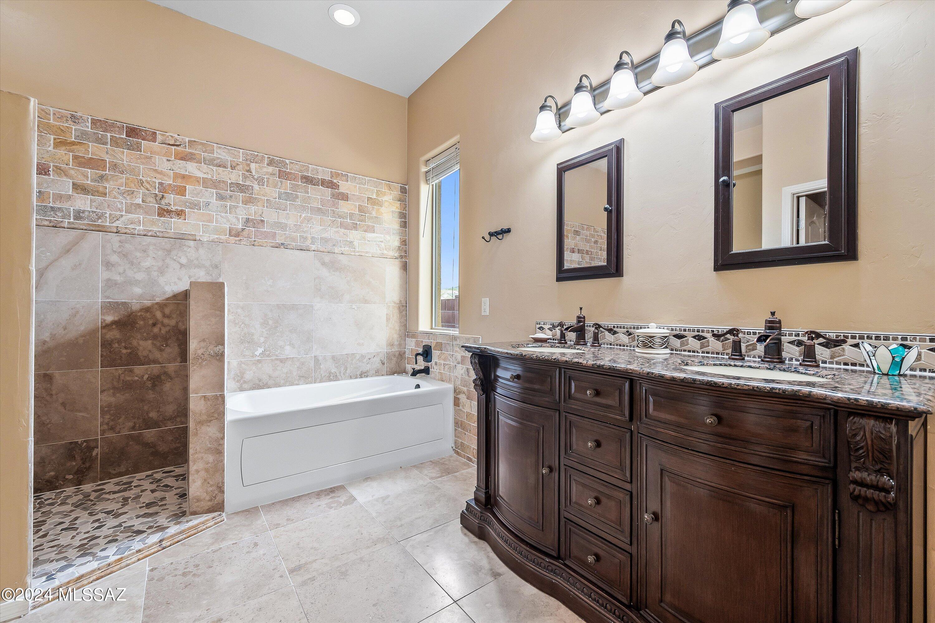 8579 North Shadow Wash Way Tucson, AZ 85743 - Photo 24 of 34 a bathroom with a granite countertop sink mirror and bathtub