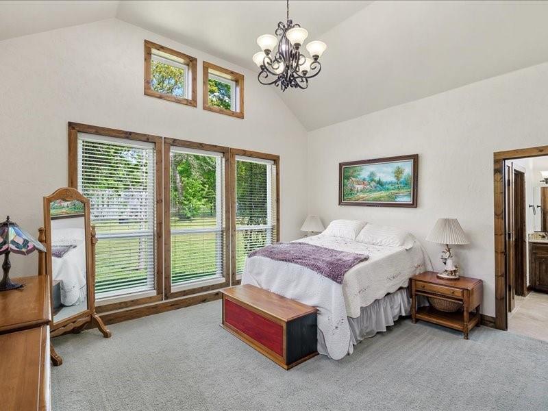6969 Highway 198 Canton, TX 75103 - Photo 27 of 40 a spacious bedroom with a bed and a chandelier