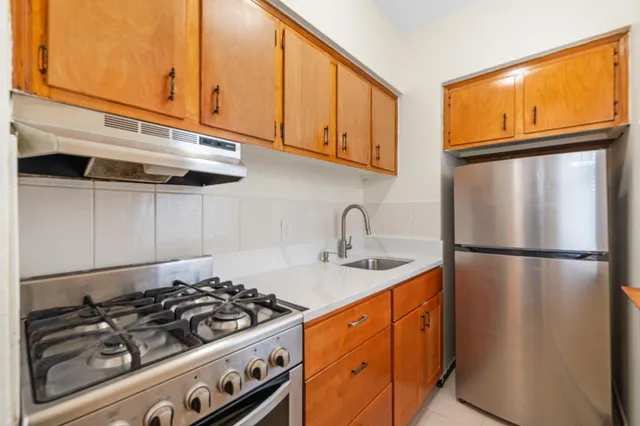 a kitchen with stainless steel appliances granite countertop a sink stove and refrigerator