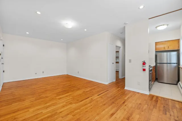 a view of empty room with wooden floor