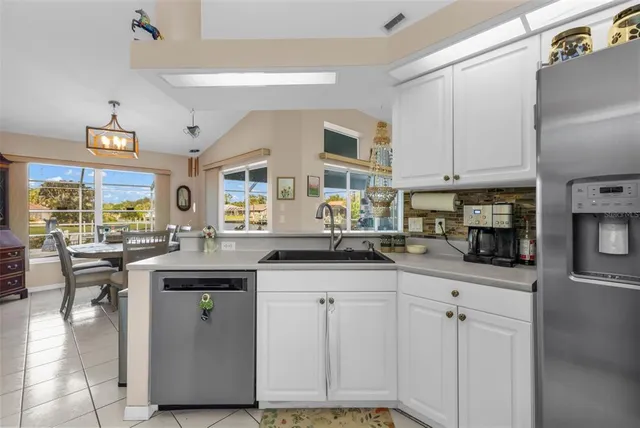a kitchen with granite countertop white cabinets and a stove top oven