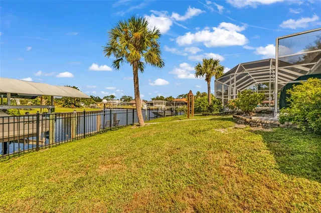 a view of a swimming pool with lawn chairs under an umbrella