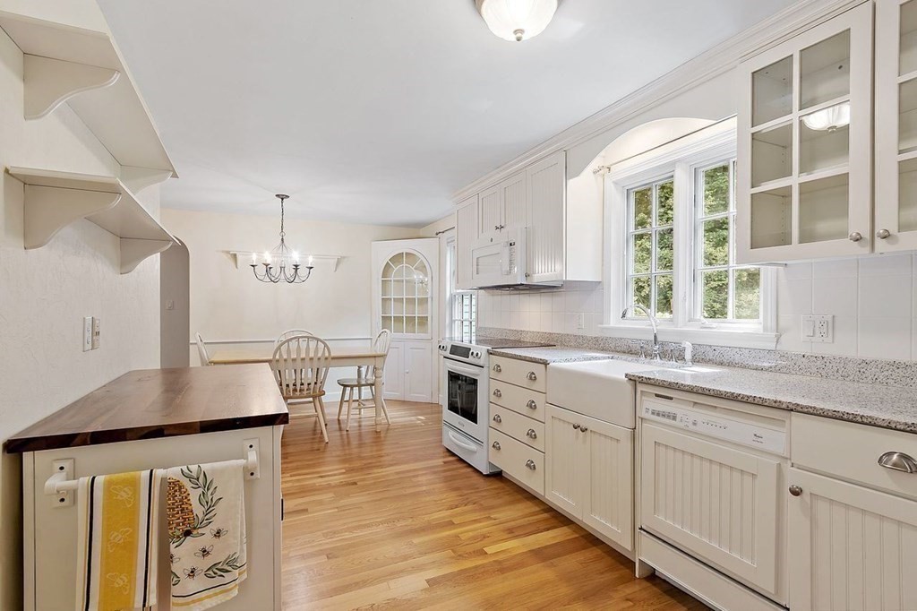 52 Edgewood Road Concord, MA 01742 - Photo 8 of 29 a kitchen with stainless steel appliances granite countertop a stove a sink a refrigerator white cabinets and wooden floor next to a window