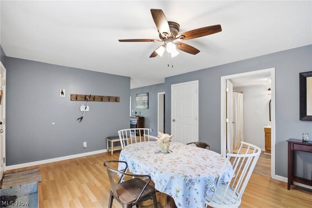 2591 Wayland Road Deerfield, OH 44411 - Photo 16 of 46 Dining area featuring wood-finish flooring, light gray walls, and an overhead ceiling fan with lighting