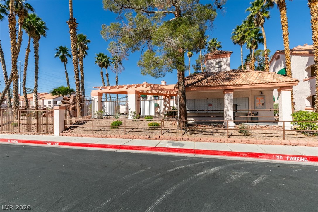 7570 West Flamingo Road, Unit 252 Las Vegas, NV 89147 - Photo 42 of 44 Secure community entrance with an inviting pergola, nestled among mature palm trees.
