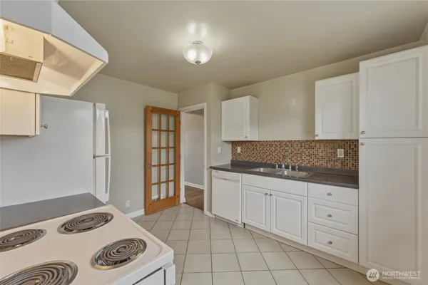 a kitchen with a sink a stove and cabinets