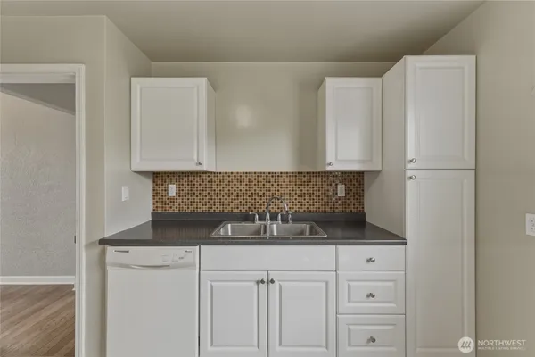 a kitchen with white cabinets and white appliances