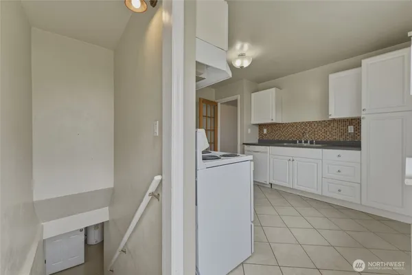 a kitchen with granite countertop white cabinets and white appliances