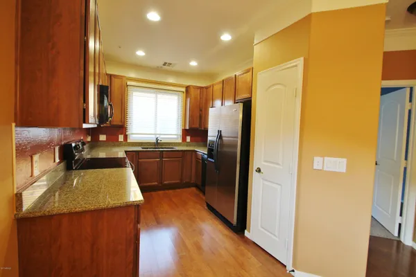 a kitchen with a refrigerator a sink and wooden cabinets