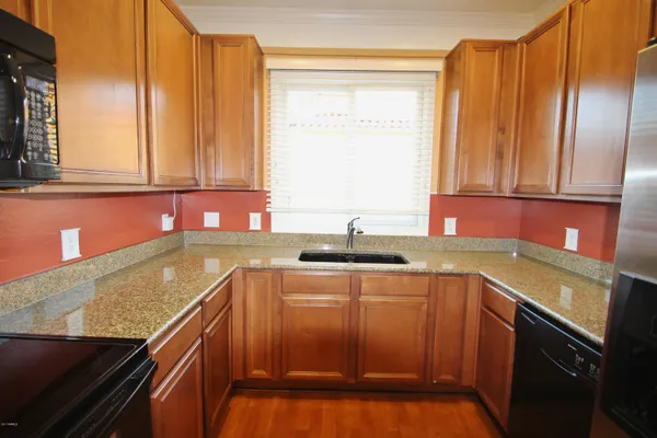 a kitchen with stainless steel appliances granite countertop a sink stove and cabinets
