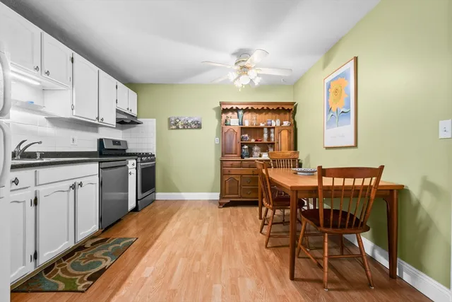 a kitchen with a table chairs microwave and cabinets