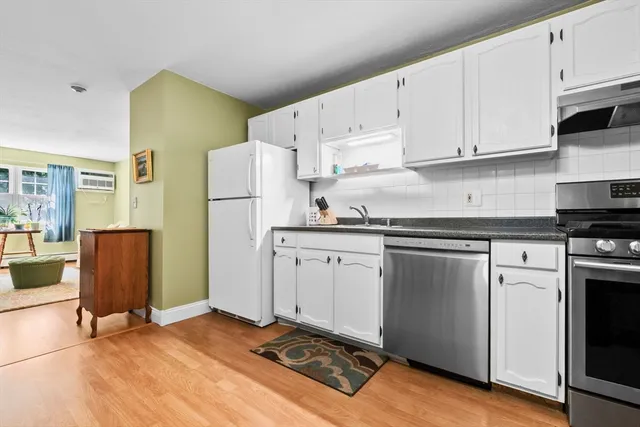 a kitchen with a refrigerator and white cabinets