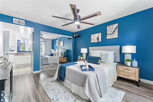 a bedroom with a bed a large window with wooden floor