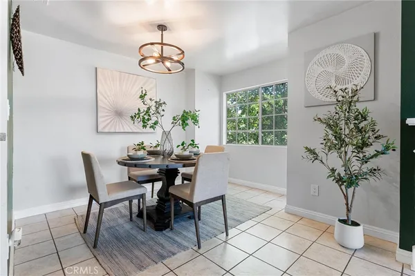 a dining room with chandelier and wooden floor