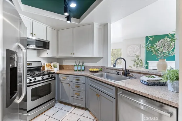 a kitchen with stainless steel appliances granite countertop a sink a stove and cabinets