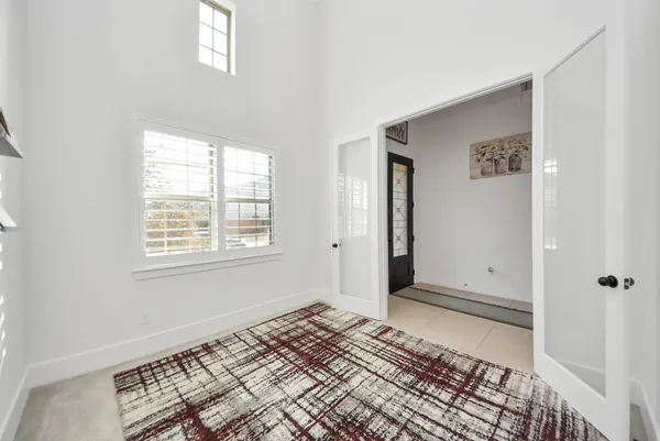 a kitchen with stainless steel appliances kitchen island granite countertop a dining table chairs and white cabinets