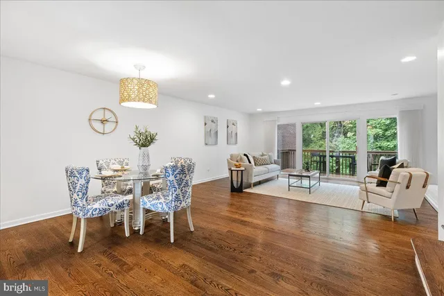 a view of a dining room with furniture a rug and wooden floor
