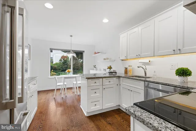 a kitchen with white cabinets and white appliances