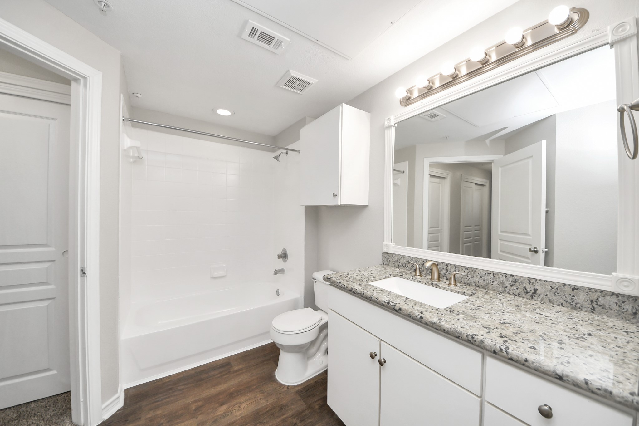 3003 Memorial Court, Unit 1139 Houston, TX 77007 - Photo 33 of 35 a bathroom with a granite countertop sink a toilet a mirror and bathtub