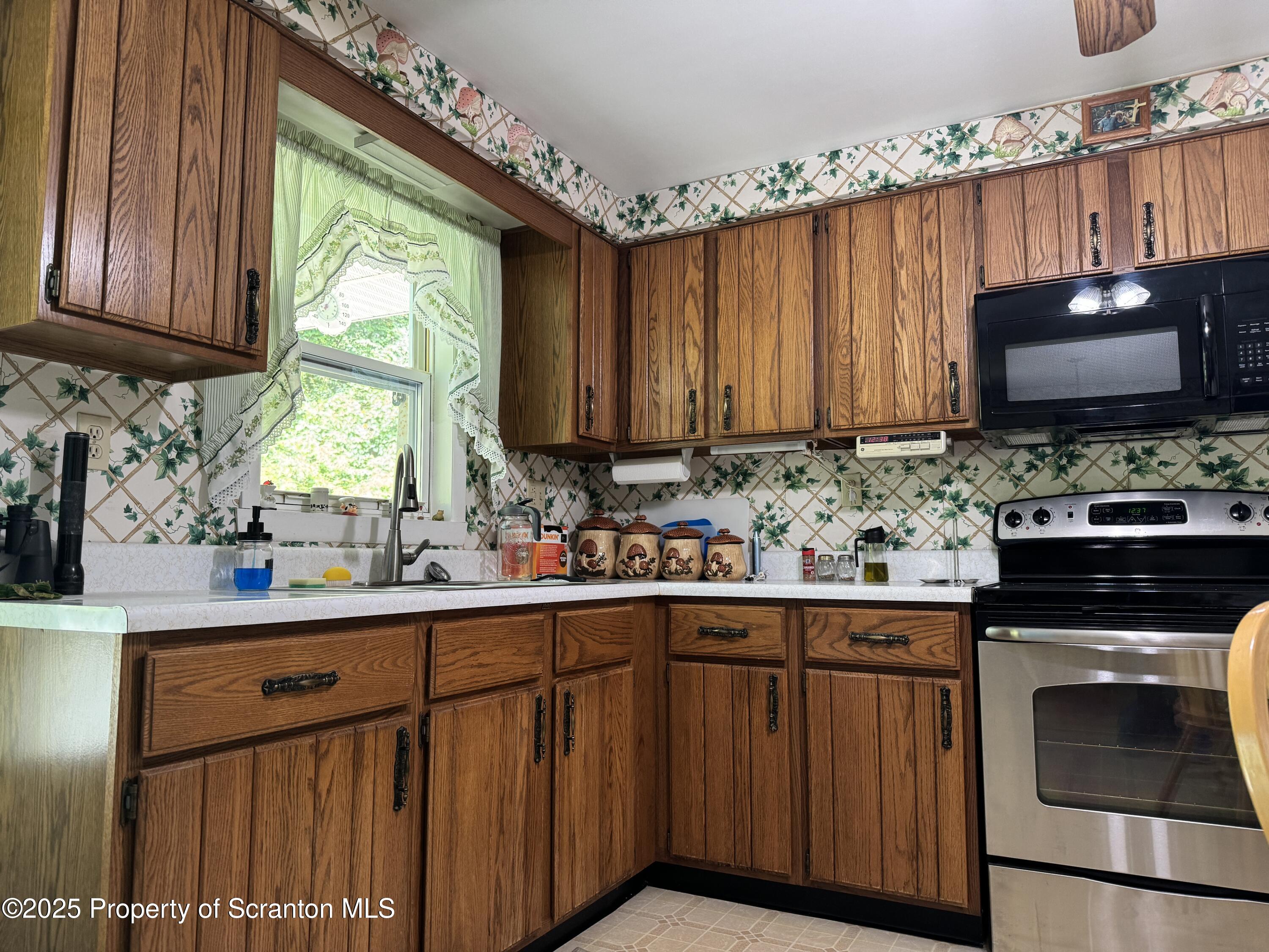 2356 Newton Ransom Boulevard Clarks Summit, PA 18411 - Photo 4 of 30 a kitchen with stainless steel appliances a sink cabinets and a wooden floor