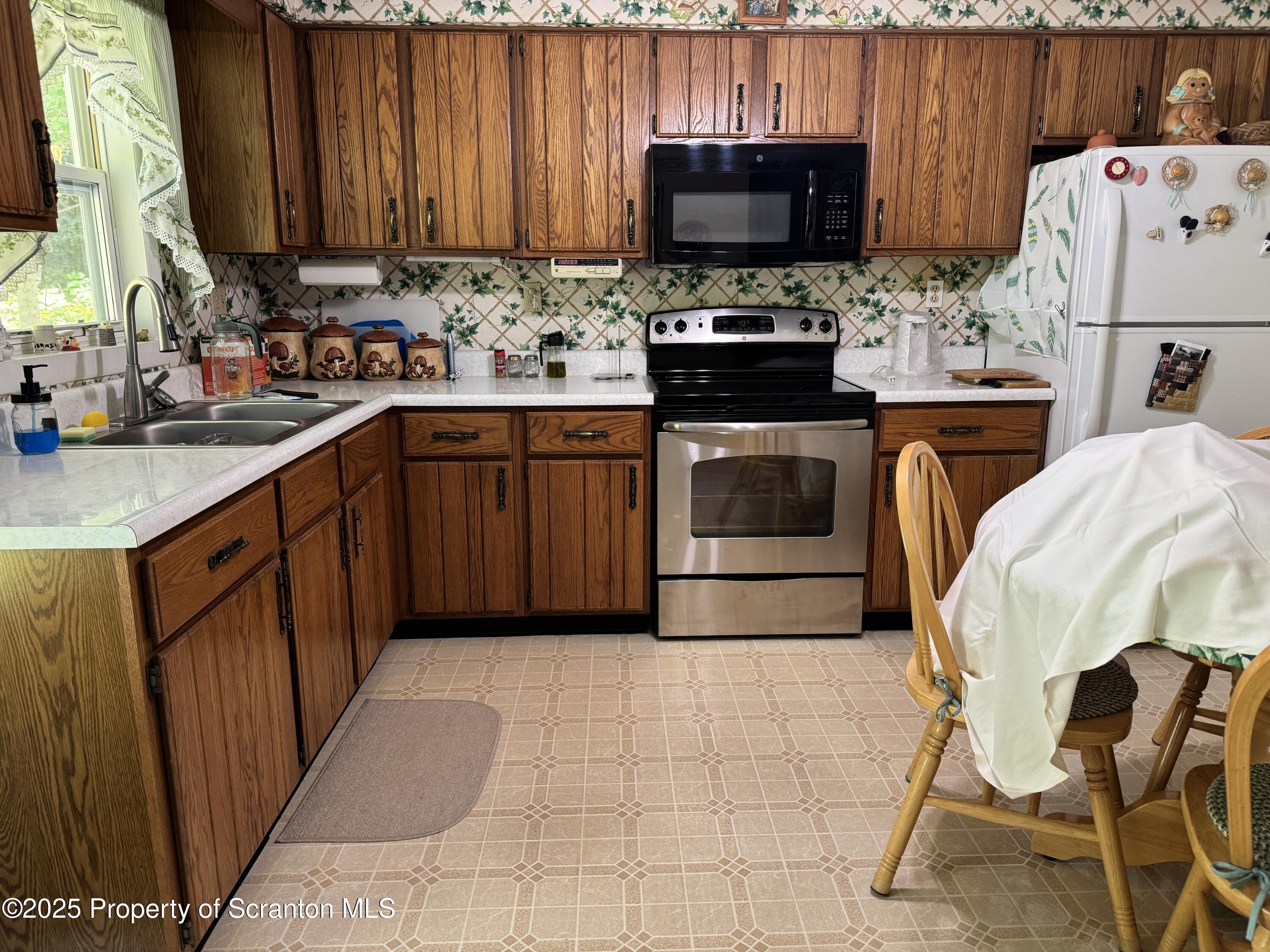 2356 Newton Ransom Boulevard Clarks Summit, PA 18411 - Photo 5 of 30 a kitchen with a stove a sink and a refrigerator