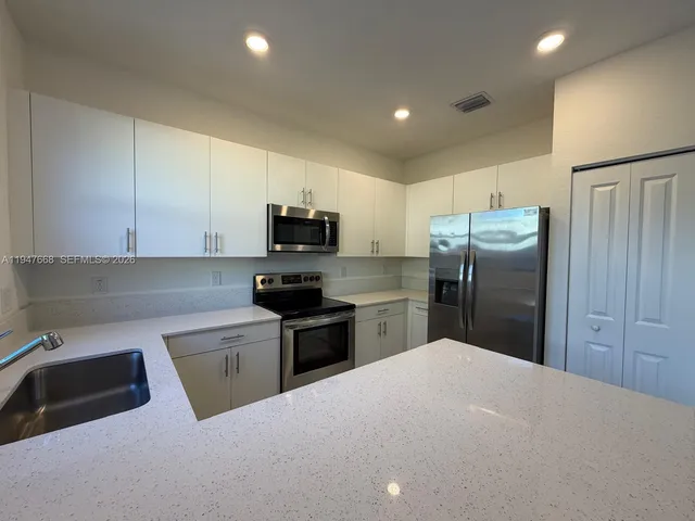 a kitchen with stainless steel appliances a refrigerator sink microwave and cabinets