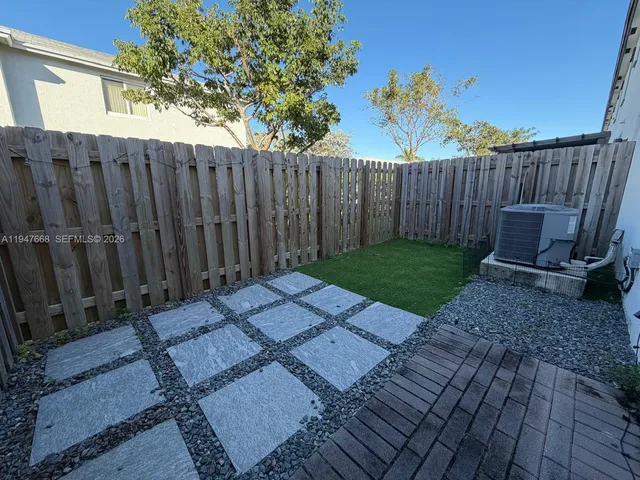 a view of a backyard with wooden fence
