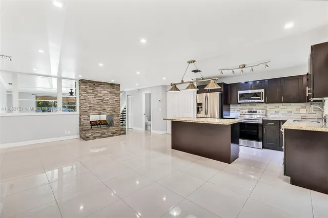 a kitchen with stainless steel appliances kitchen island granite countertop a stove and cabinets
