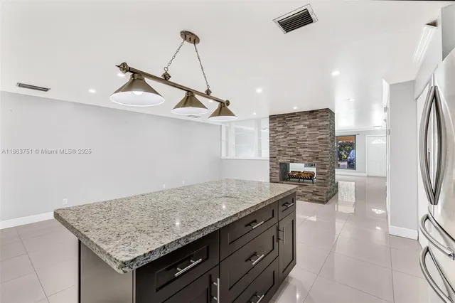 a kitchen with a stove a faucet a chandelier and a refrigerator