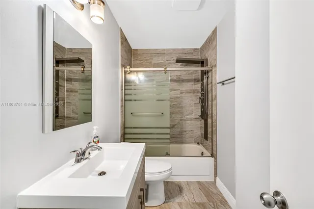 a bathroom with a bathtub shower sink vanity and toilet