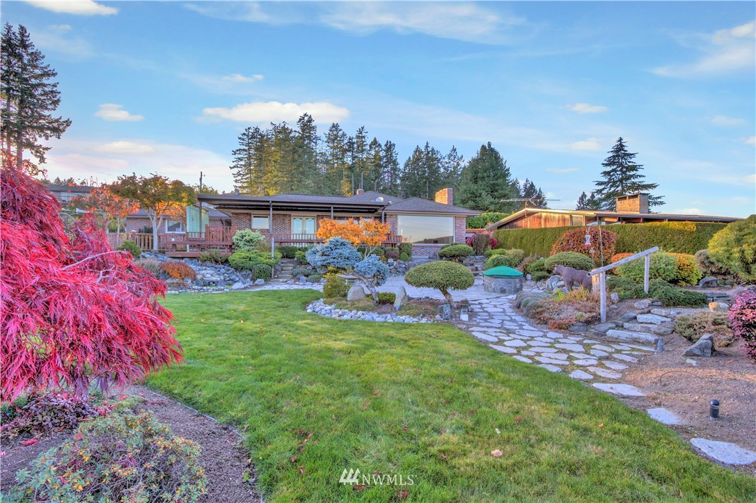 7002 Soundview Drive Gig Harbor, WA 98335 - Photo 4 of 33 a view of a house with a garden and trees