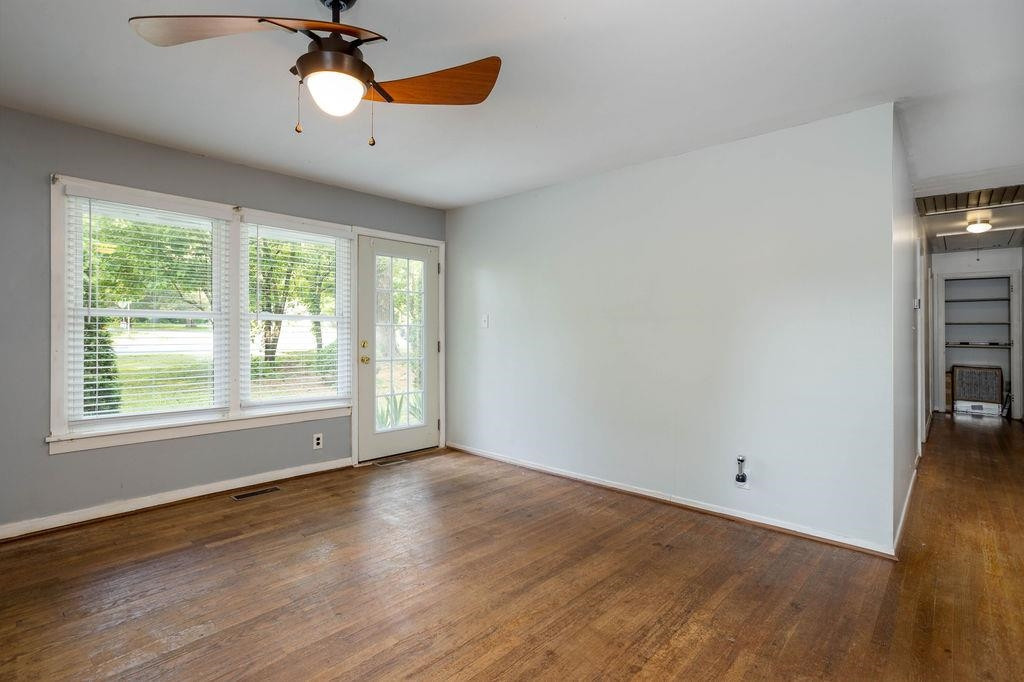 307 South King Charles Road Raleigh, NC 27610 - Photo 4 of 32 an empty room with wooden floor fan and windows