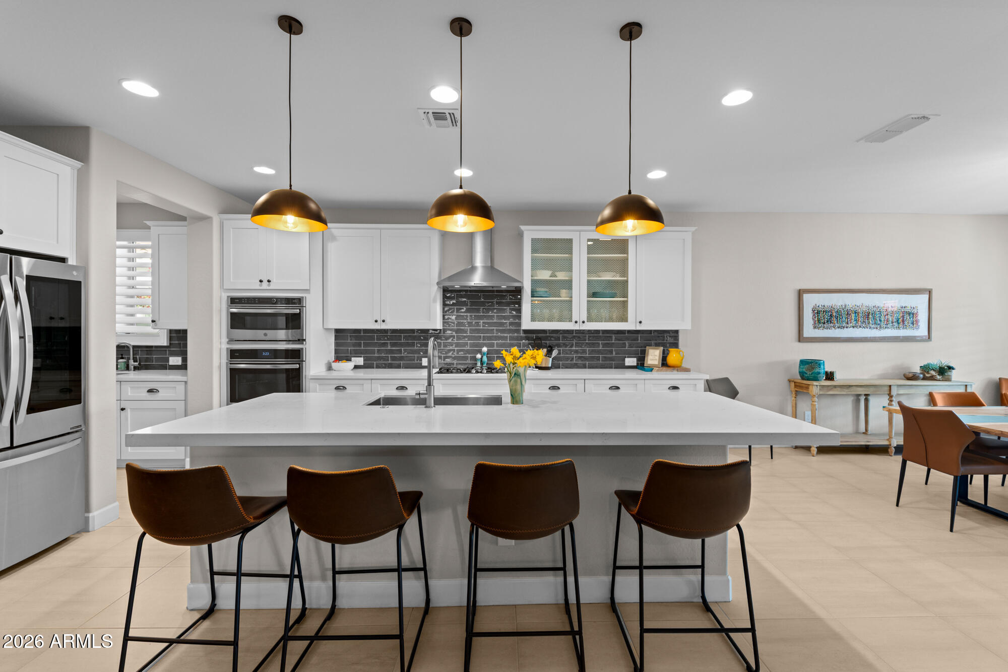16705 Virginia Avenue Goodyear, AZ 85395 - Photo 11 of 56 a kitchen with stainless steel appliances granite countertop a sink a stove a refrigerator and chairs