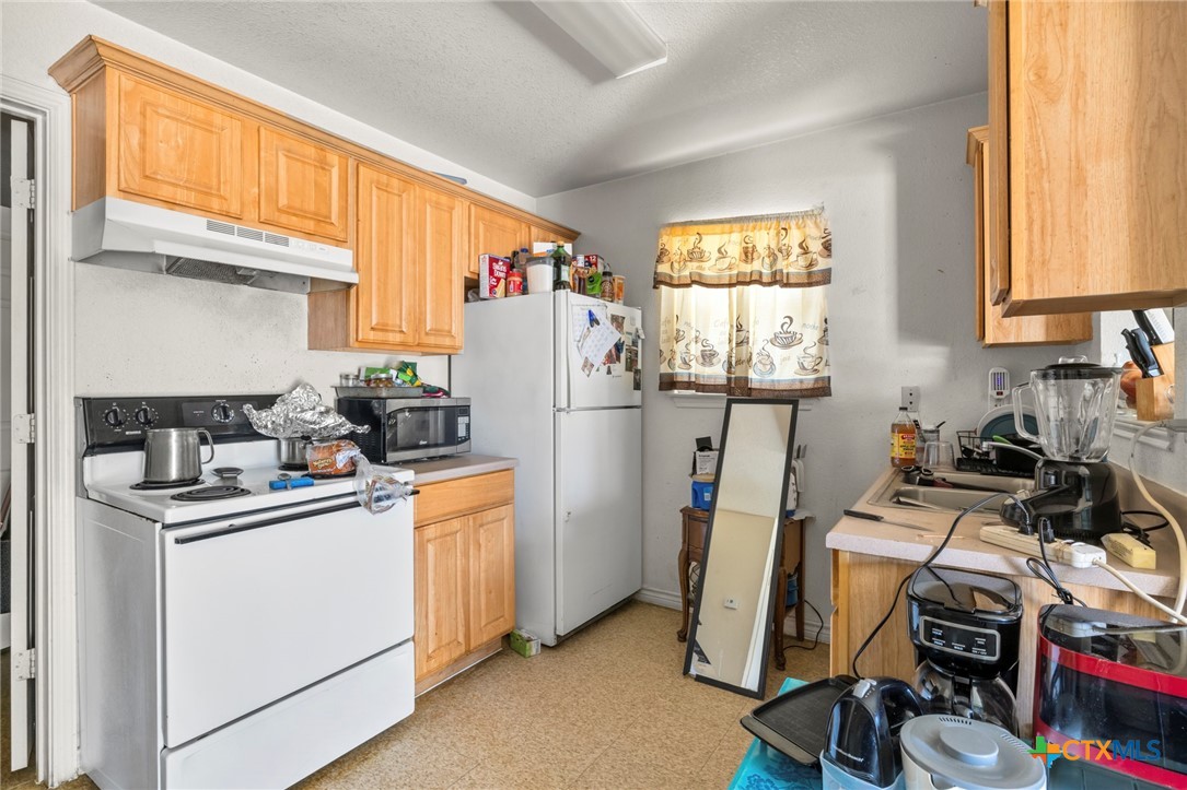 120 South 23rd Street Temple, TX 76504 - Photo 11 of 12 a view of a kitchen with fridge and workspace