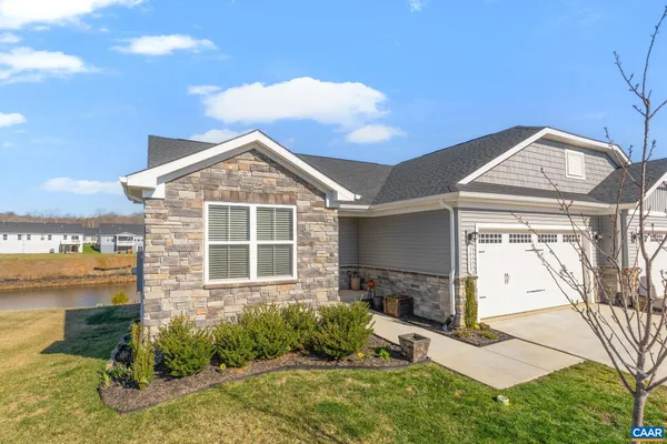 a kitchen with stainless steel appliances granite countertop a dining table chairs refrigerator and microwave