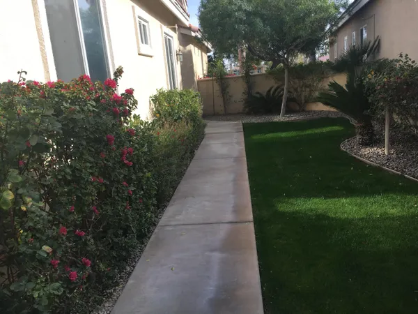a view of a chairs and table in a lot of back yard of the house