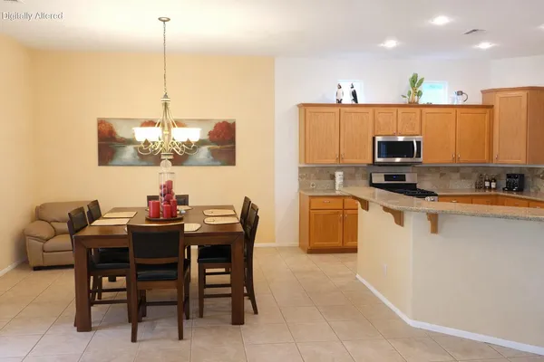 a view of kitchen with kitchen island stainless steel appliances a dining table and chairs