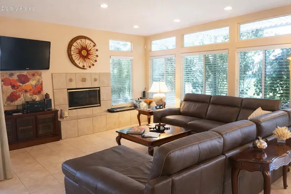a living room with furniture a fireplace and a flat screen tv