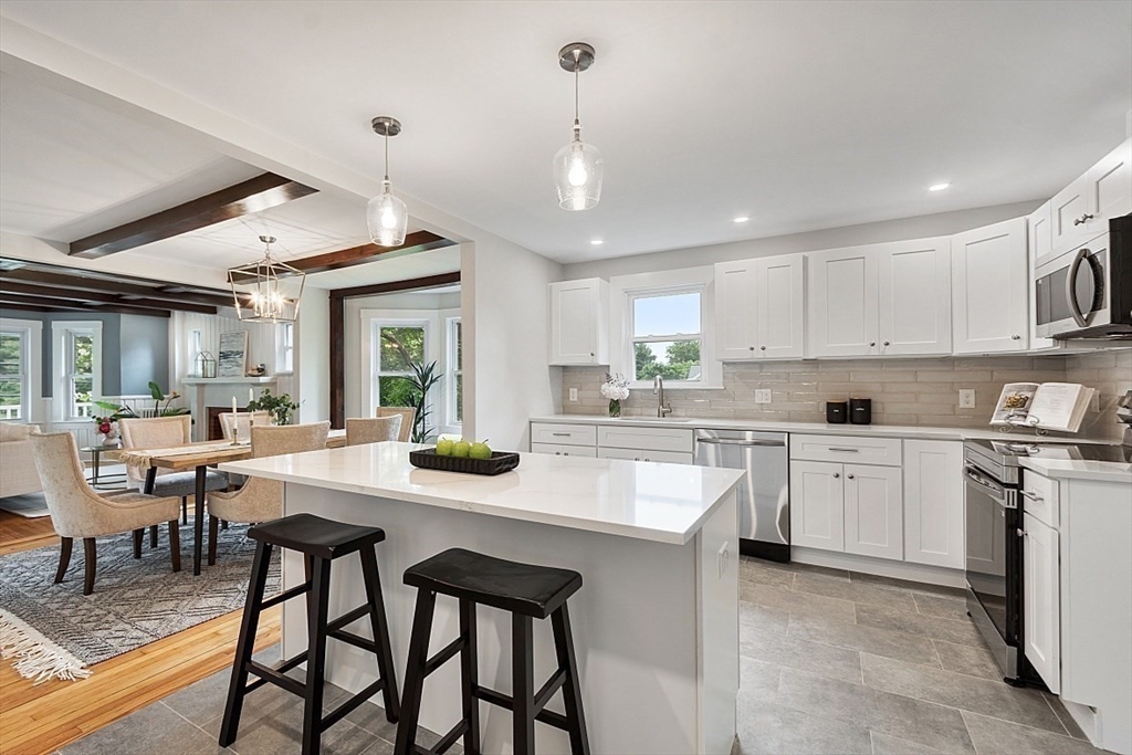 136 Groton Road North Chelmsford, MA 01863 - Photo 17 of 41 a kitchen with stainless steel appliances kitchen island granite countertop a table chairs sink and cabinets