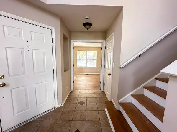 a view of a hallway with wooden floor and staircase