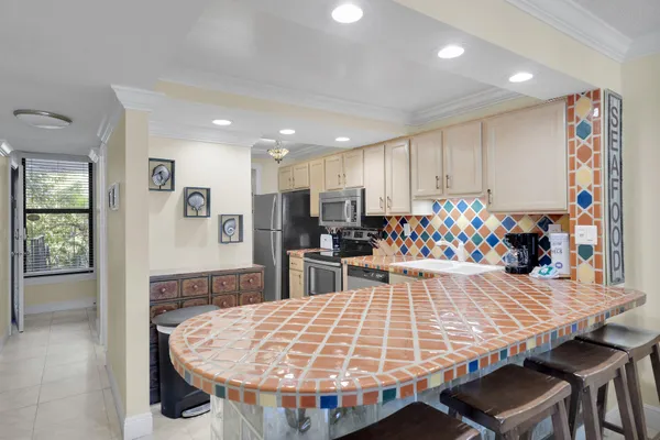 a kitchen with stainless steel appliances granite countertop a stove and white cabinets