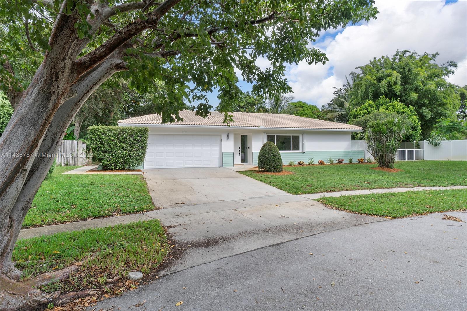 900 Northwest 9th Way Boca Raton, FL 33486 - Photo 2 of 48 a front view of a house with a yard and garage