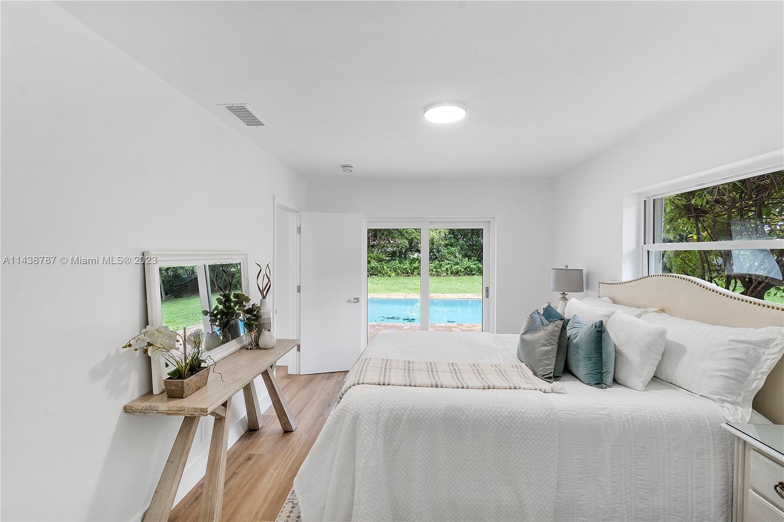 900 Northwest 9th Way Boca Raton, FL 33486 - Photo 24 of 48 a bedroom with a bed and large windows