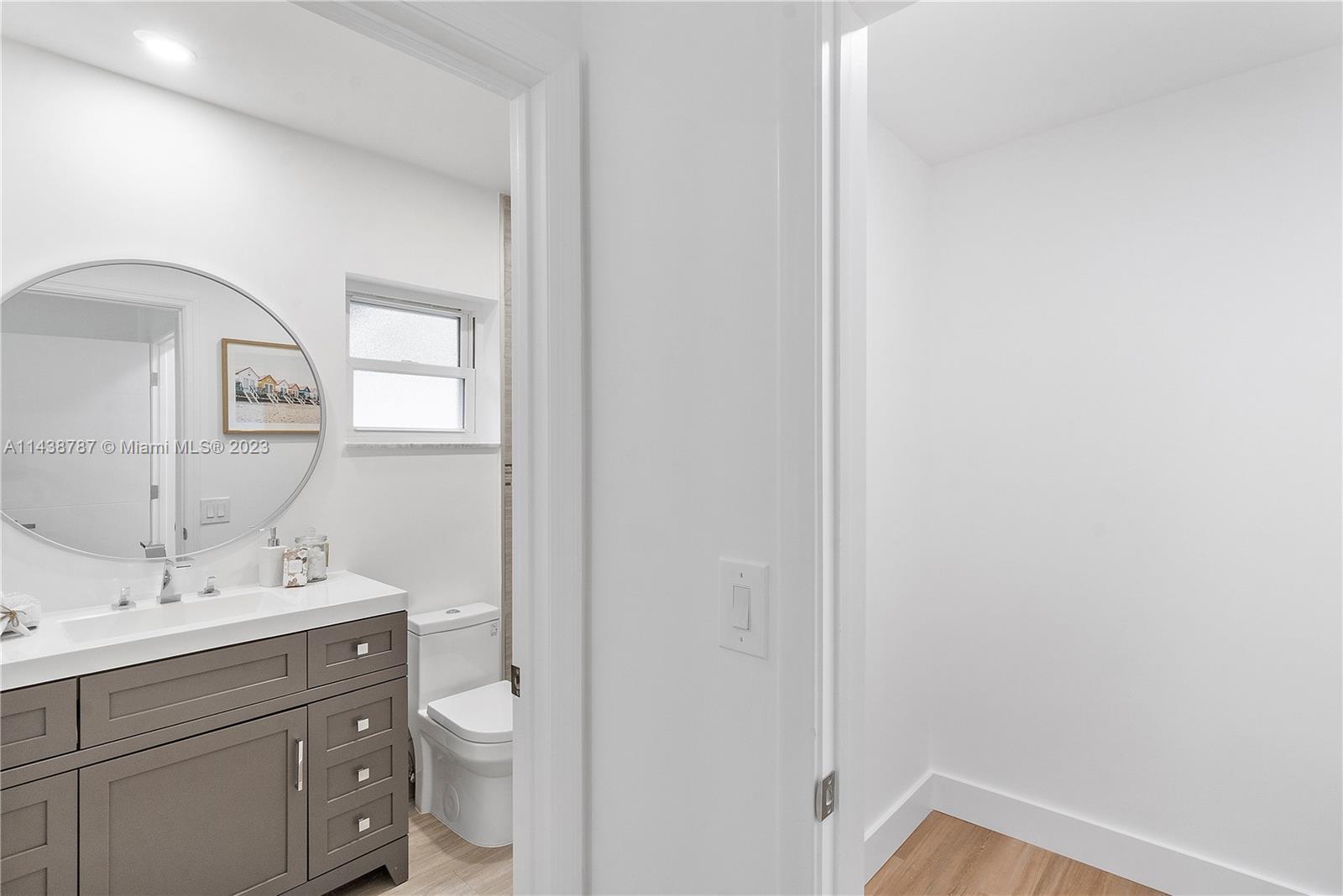 900 Northwest 9th Way Boca Raton, FL 33486 - Photo 29 of 48 a bathroom with a toilet a sink a mirror and vanity