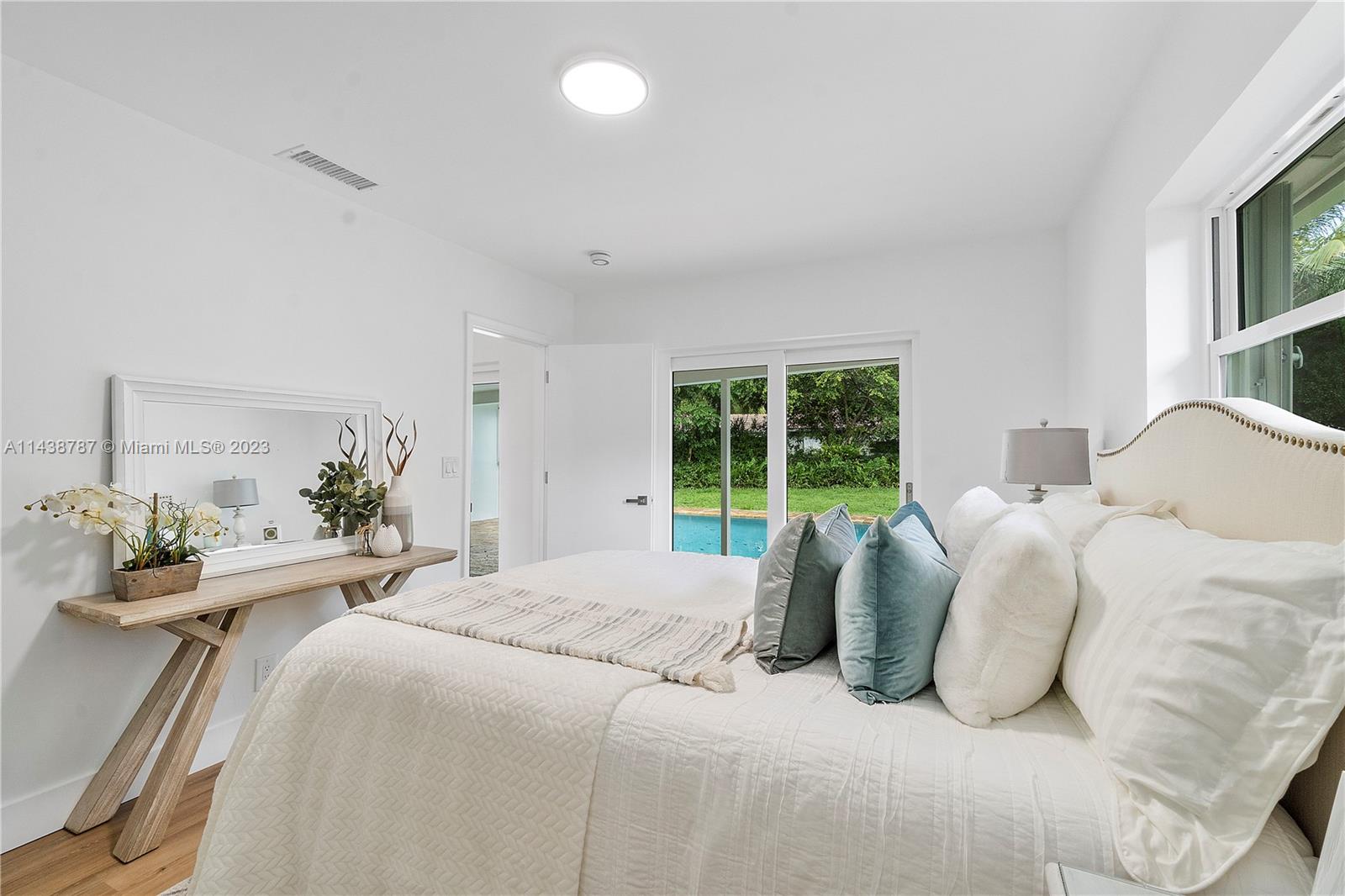 900 Northwest 9th Way Boca Raton, FL 33486 - Photo 31 of 48 a bedroom with a bed mirror and a large window