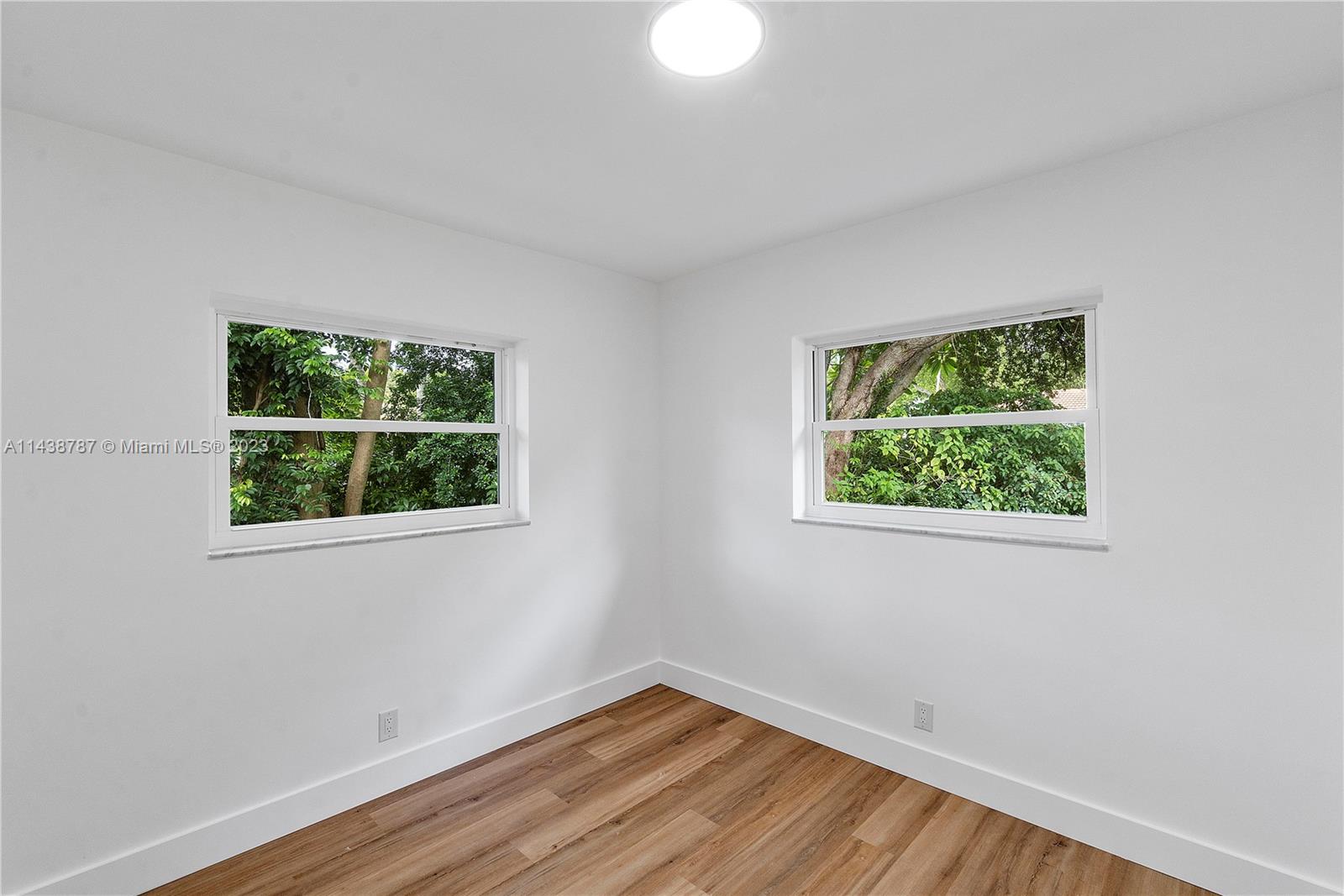 900 Northwest 9th Way Boca Raton, FL 33486 - Photo 38 of 48 a view of an empty room with wooden floor and a window