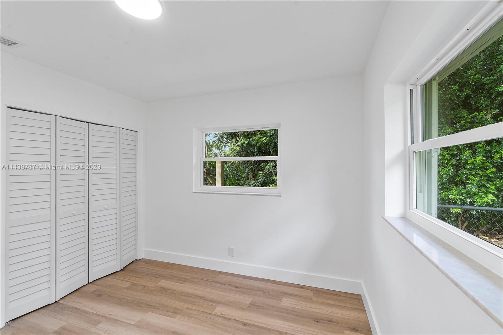 900 Northwest 9th Way Boca Raton, FL 33486 - Photo 39 of 48 an empty room with wooden floor and windows